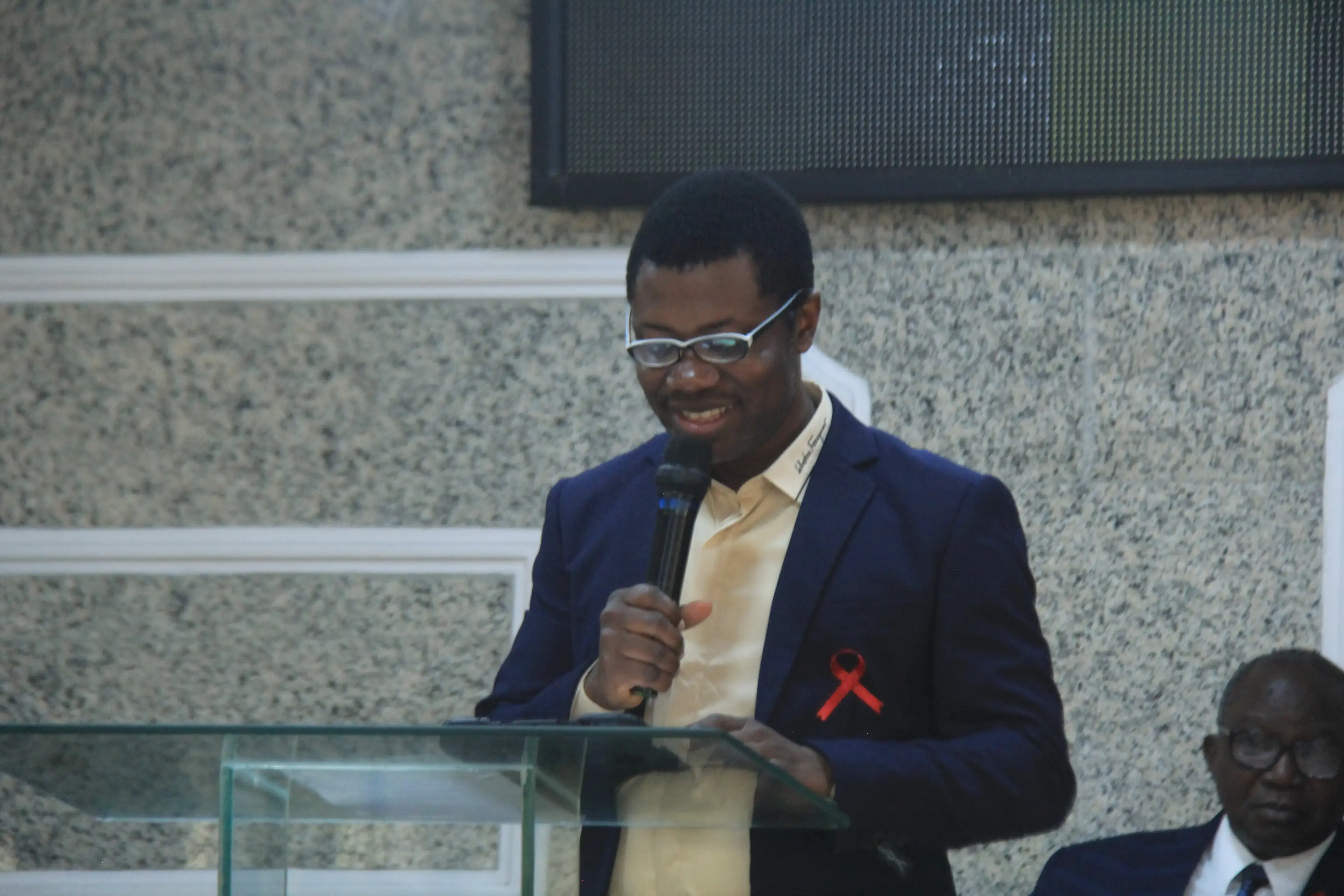 Semiu Ajala giving a speech at a podium during a teacher training closing ceremony